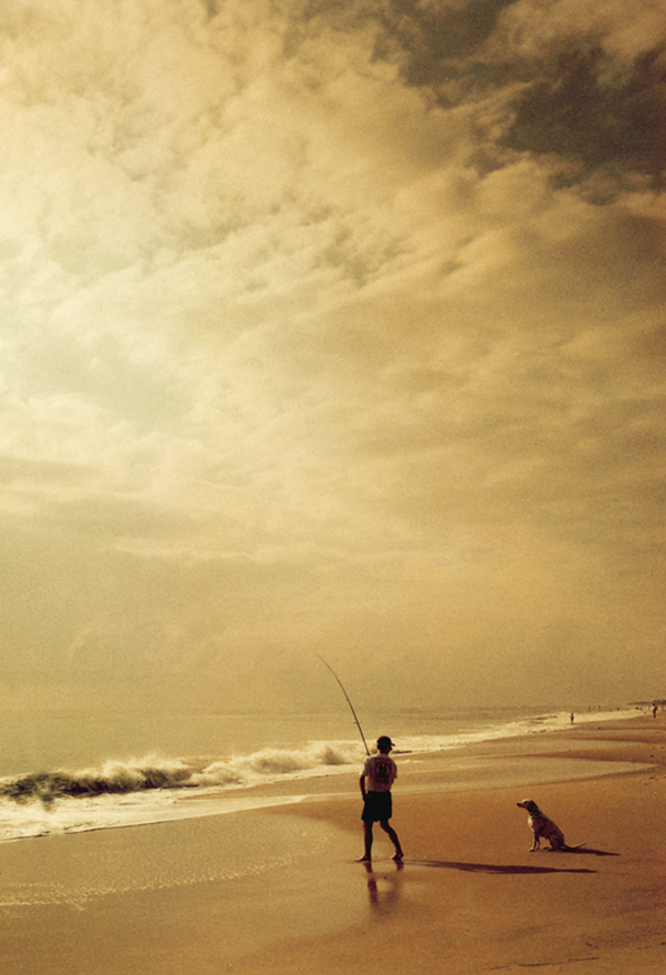 Professional photography in Richmond, VA, of a man fishing on the beach.